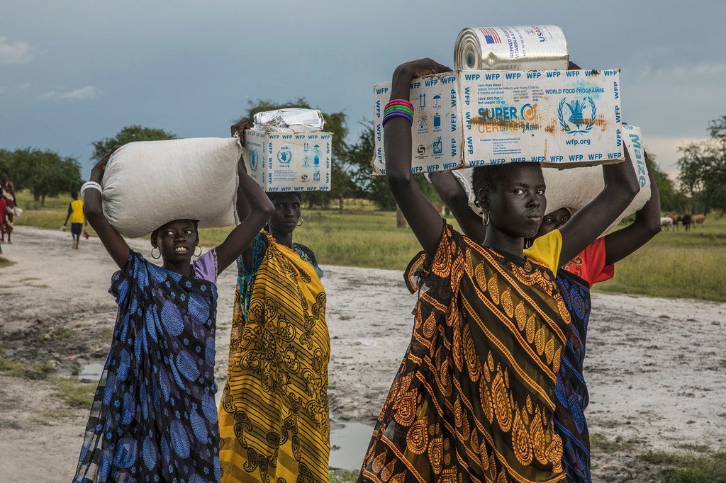 Unas mujeres transportan la ayuda alimentaria recibida en un punto de distribución de emergencia del PMA en Thaker, estado de Unity, Sudán del Sur (archivo).